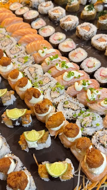 Mesa com dezenas de peças de sushi montadas para um evento