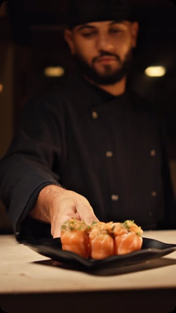 Chef Thiago Cardoso servindo um prato de sushi